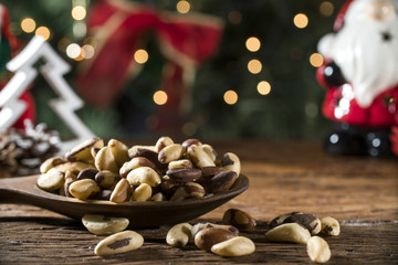 Brazilian Nuts: Castanha do Para into a bowl  on the board with blurred christmas background