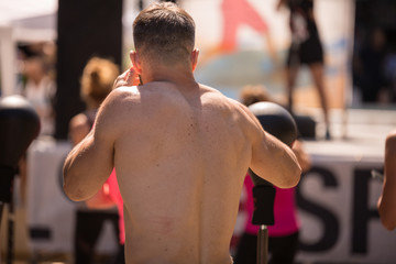 Fitness and Exercising Concept: Boy with Naked Torso Having Workout with Boxing Speed Ball Outdoor at Gym