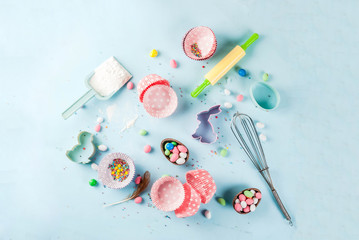 Sweet baking concept for Easter,  cooking background with baking - with a rolling pin, whisk for whipping, cookie cutters, sugar sprinkling, flour. Light blue background, top view copy space