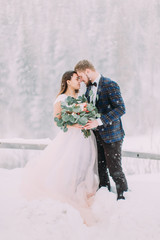 Winter love story. Beautiful couple in winter forest. Long-awaited meeting of two lovers. Young...