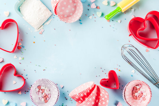 Sweet baking concept for Valentine's day,  cooking background with baking - with a rolling pin, whisk for whipping, cookie cutters, sugar sprinkling, flour. Light blue background, top view copy space