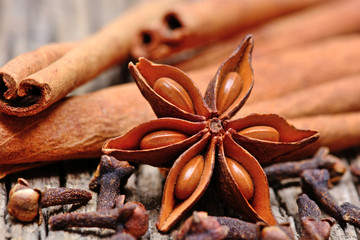Anise star with cinnamon sticks and cloves on table