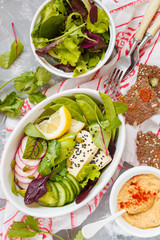 Green salad, buddha bowl with tofu, vegetables, hummus with flax crispbread.