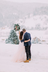 Winter love story. Beautiful couple in winter forest. Long-awaited meeting of two lovers. Young pretty pair of lovers. Winter. Date. A pair of lovers on a date in the mountains. 