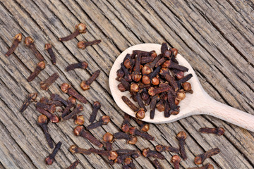 Cloves in a wooden spoon on table