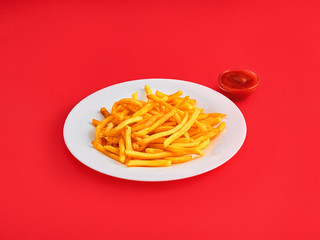 French fries on a plate, isolated on red background