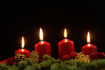Red candles of an Advent wreath with fir branches