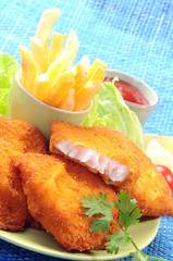 Breaded Fried fish with potato fries and tomato ketchup with lemon cherry tomato
