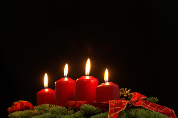 Red candles of an Advent wreath with fir branches
