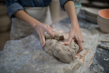 Fototapeta premium Mid section of female potter molding a clay