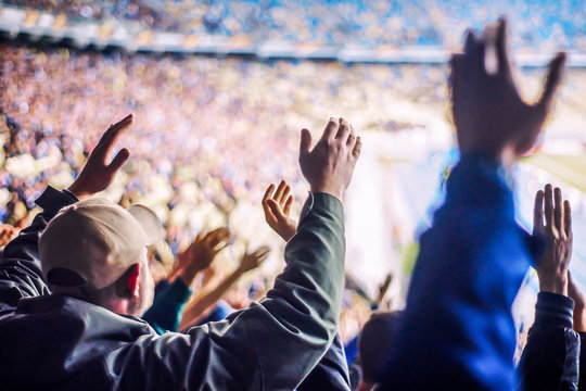 Football fans clapping on the podium of the stadium