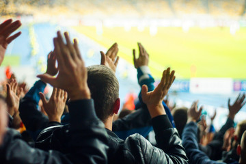 Football fans clapping on the podium of the stadium