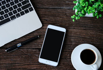 Office table at home with smartphone
,Laptop,Hot coffee and cactus, copy space,Top view,flat lay.
