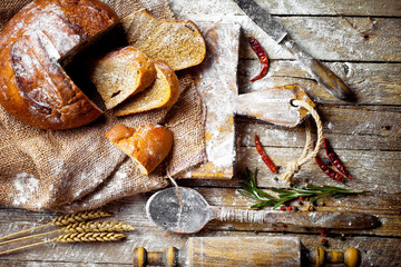 Bread and pastries in a composition with kitchen accessories on an old background