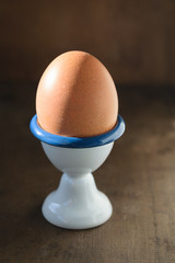 Colorful easter eggs in egg cup on wooden background