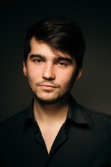young brunette guy on a dark background