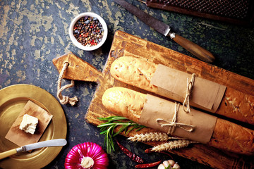 Bread and pastries in a composition with kitchen accessories on an old background