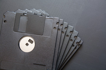 Many black computer diskette on dark background.