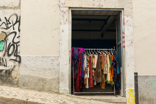 rack of dresses hanging in a shop entrance, Lisbon, Portugal