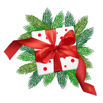 Christmas vector realism mesh gift box with a red bow on christmas tree branches on isolated white background