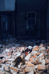 Vintage doll lying in rubble of demolished house.