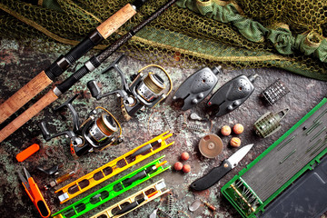 Fishing rods and spinnings in the composition with accessories for fishing on the old background on...