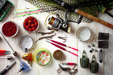 Fishing rods and spinnings in the composition with accessories for fishing on the old background on the table