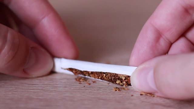 Pouring tobacco out from the cigarette