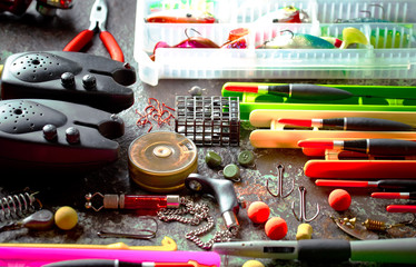 Fishing rods and spinnings in the composition with accessories for fishing on the old background on the table
