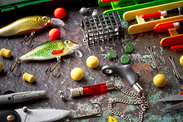 Fishing rods and spinnings in the composition with accessories for fishing on the old background on the table