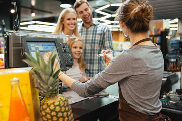 Beautiful family paying for their groceries