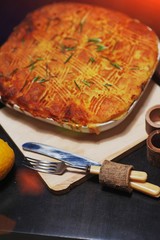 a Traditional potato pie for a family dinner, baked until Golden brown in the oven, on a dark background closeup.