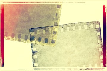 Vintage red and sepia film strip frame on old and damaged paper background.