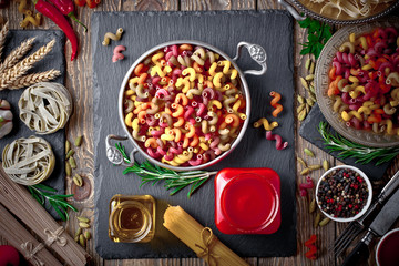 Raw pasta in the composition on the table with items for cooking