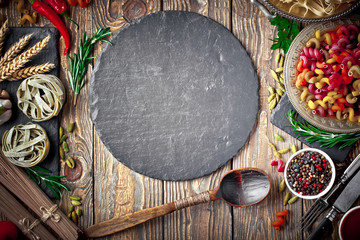 Raw pasta in the composition on the table with items for cooking