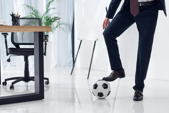 cropped shot of businessman with soccer ball at workplace in office