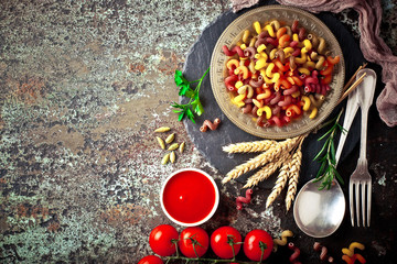 Raw pasta in the composition on the table with items for cooking