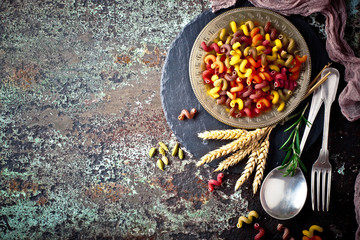Raw pasta in the composition on the table with items for cooking