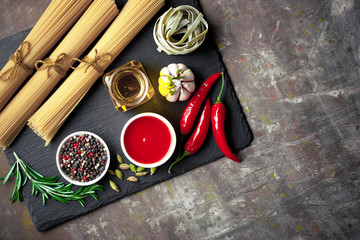 Raw pasta in the composition on the table with items for cooking
