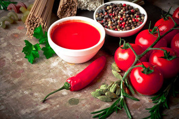 Raw pasta in the composition on the table with items for cooking