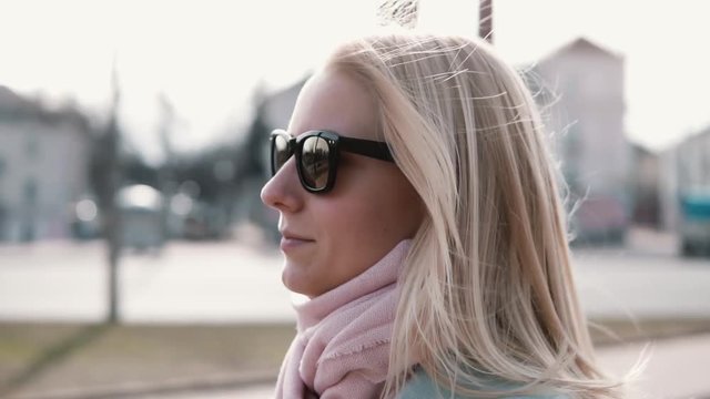 Slow motion portrait of confident pretty woman. Attractive successful Caucasian female smoothing flying hair sunglasses.