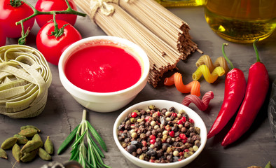 Raw pasta in the composition on the table with items for cooking