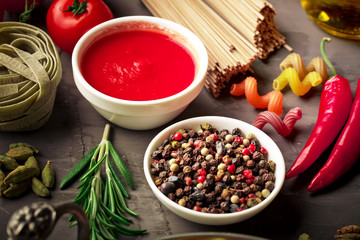 Raw pasta in the composition on the table with items for cooking