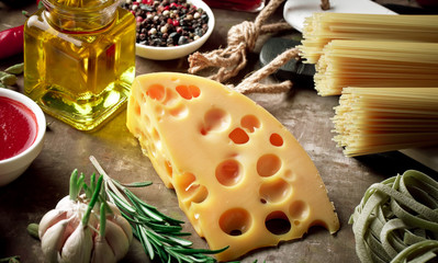 Raw pasta in the composition on the table with items for cooking