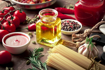 Raw pasta in the composition on the table with items for cooking