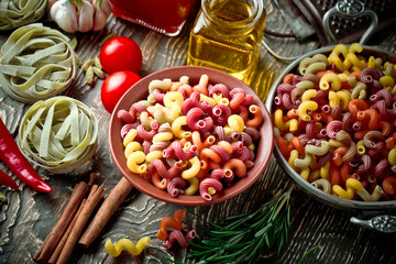 Raw pasta in the composition on the table with items for cooking