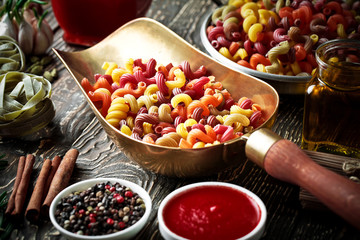 Raw pasta in the composition on the table with items for cooking