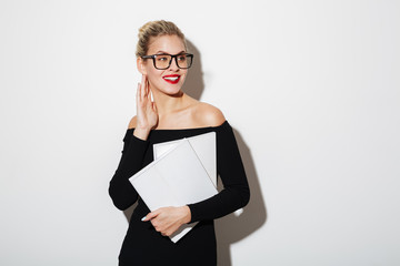 Fototapeta premium Pleased business woman in dress and eyeglasses holding documents