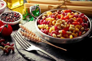 Raw pasta in the composition on the table with items for cooking