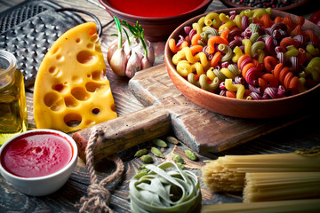 Raw pasta in the composition on the table with items for cooking